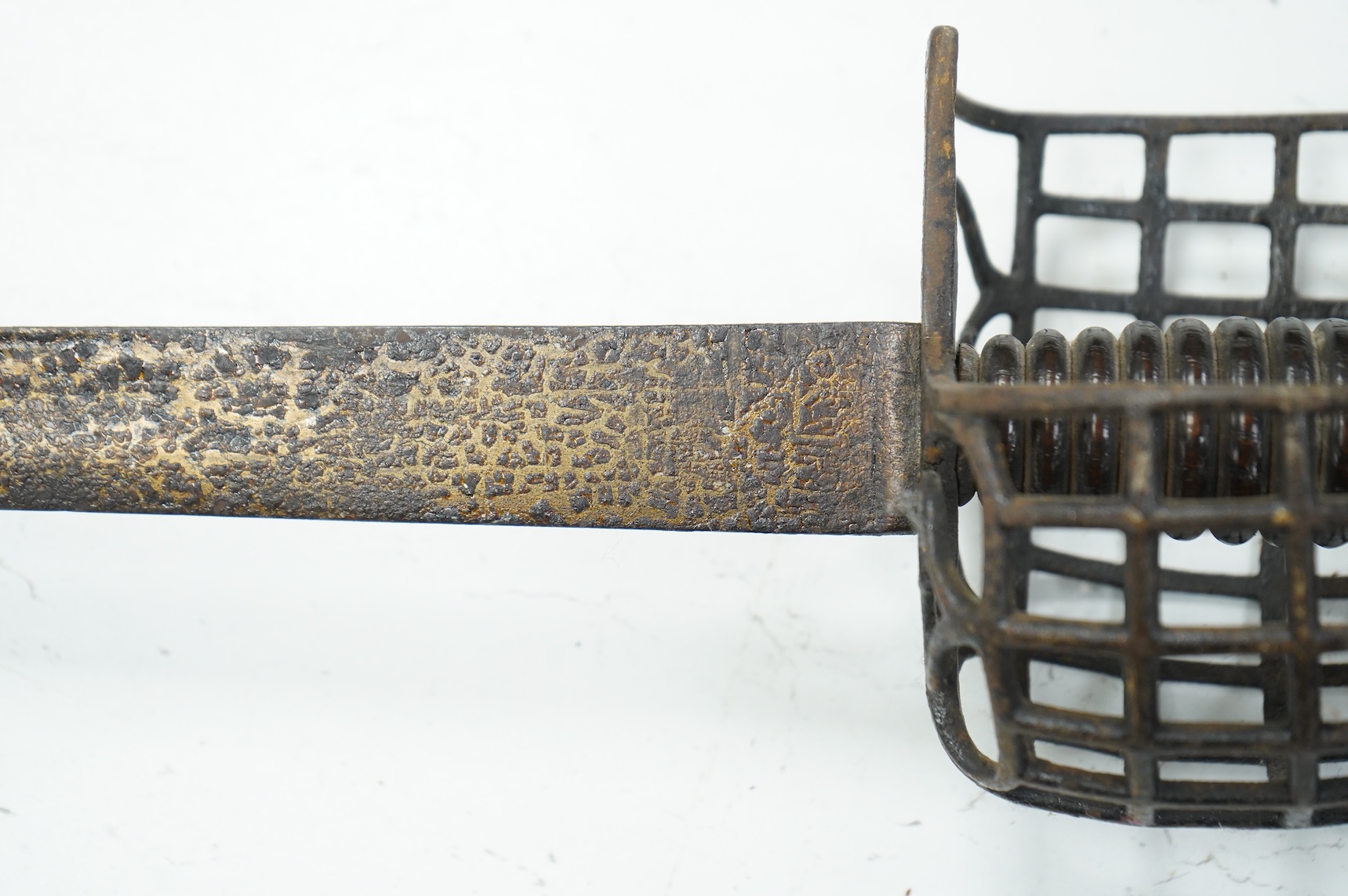 A basket hilted backsword of c.1750, with single edge blade cut with a pair of fullers, three-quarter basket guard comprising many rectangular openings, blade 90.5cm